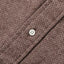 The placket of the brown herringbone flannel with a white button.