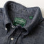 A closeup of the button down collar of the navy herringbone flannel with a green Gitman brothers vintage tag.