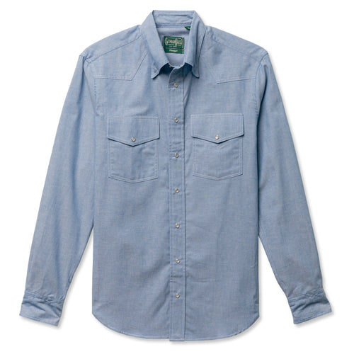 A blue western shirt with two chest pocket, made from a chambray fabric with pearl snap buttons.