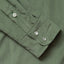 A sage shirt sleeve and cuff, three white buttons.