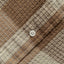A closeup look of the tan waffle placket with a white button.