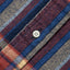 A closeup look of the red madras placket with a white button.