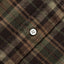 A closeup look of the brown madras placket with a white button.