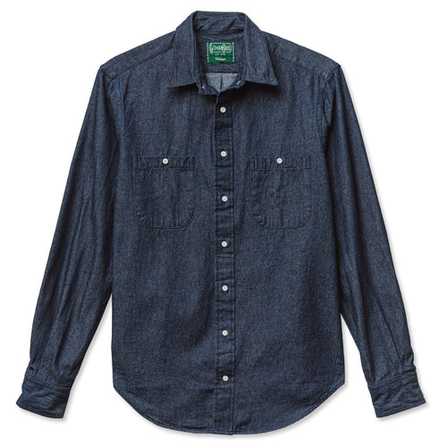 A dark denim work shirt with two chest pockets and white buttons, includes barrel cuffs and made from 100% cotton made in the USA.